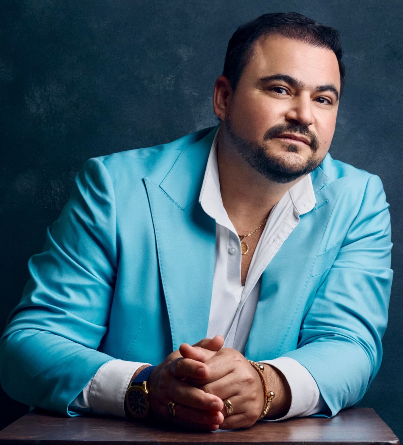 Dr. Hendry Pascual in a turquoise blazer and white shirt against a dark blue backdrop