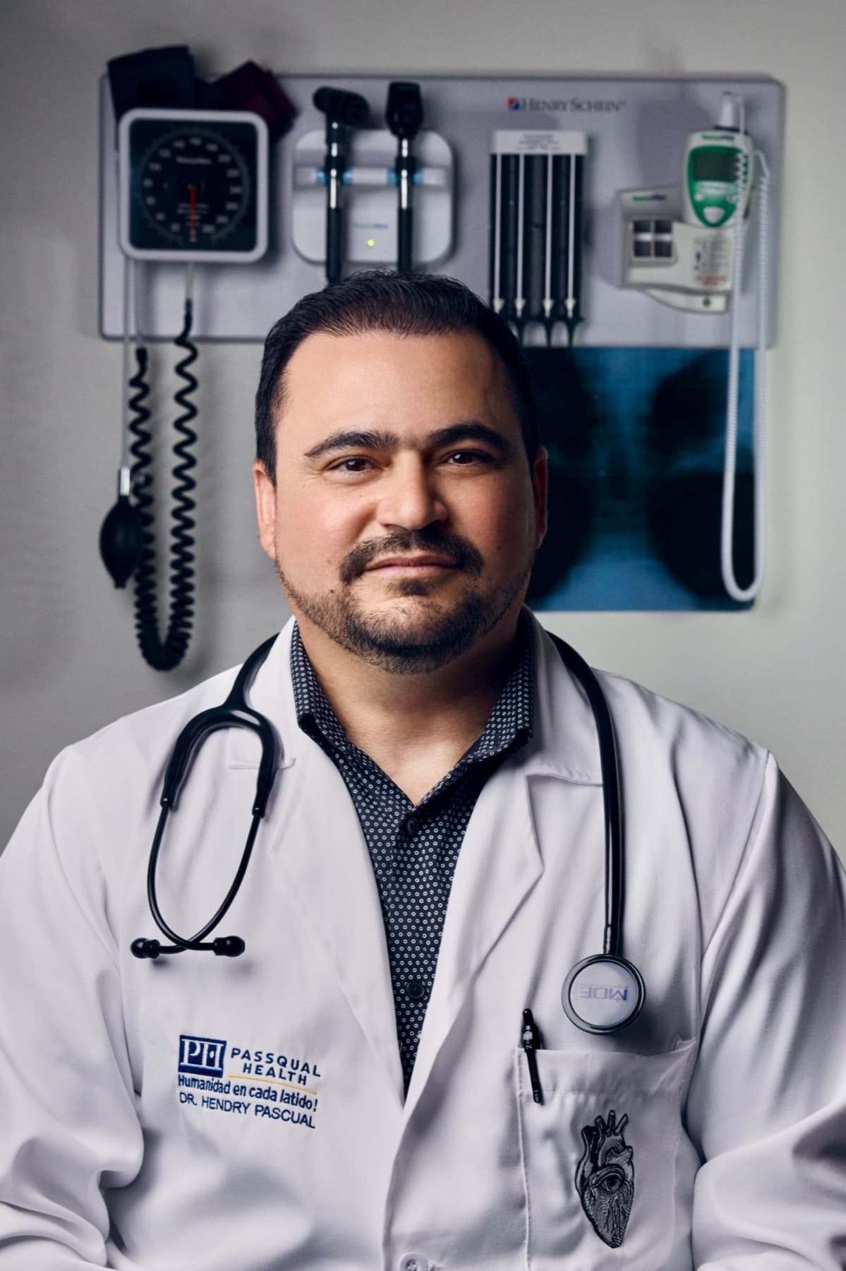 Dr. Hendry Pascual in a PassQual Health white coat with a stethoscope, in an exam room
